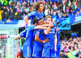Chelsea players pile in to celebrate their team's second goal scored by Andre Schurrle (R) during their 6-0 win over Arsena