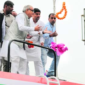 Chief Minister Bhupinder Singh Hooda tries to catch a garland tossed at him by a party supporter during a road show in Panchkula on Sunday