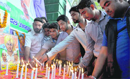 Youths light candles to pay tributes to Bhagat Singh, Rajguru and Sukhdev at Gandhi Park in Dehradun on Sunday.