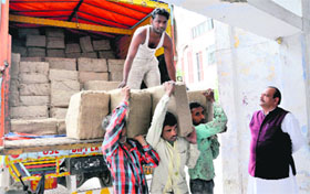 Workers shift election campaign material to the Congress Bhavan in Dehradun on Sunday.