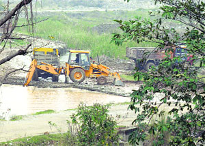 Illegal mining takes place with the help of a JCB machine in a river in the Nurpur area of Kangra district