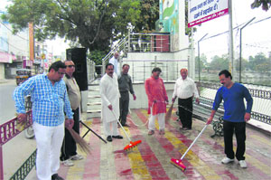 Members of the Jila Punjabi Welfare Sabha clean the area near statues of martyrs in Kaithal on Sunday.