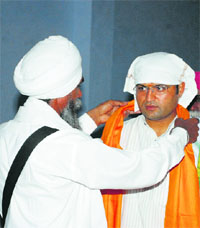 A Sikh cleric presents a siropa to Ashok Tanwar on the opening of his election office at Ratia in Fatehabad on Sunday. 