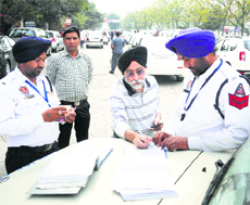Policemen challan a violator near Bhai Bala Chowk in Ludhiana on Sunday.