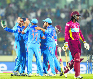 The Indian team celebrates as Chris Gayle (34 ) returns to the pavilion on Sunday.