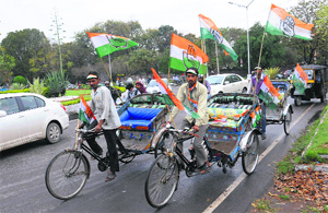 Rickshaw-pullers carrying Congress flags move about in Chandigarh.