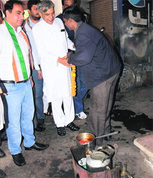 Congress candidate Pawan Bansal meets a tea vendor during his poll campaign at the Sector 7 market.