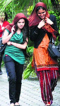 Girls try to save themselves from rain in Jalandhar on Monday.