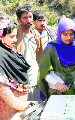 People being taught how to use an electronic voting machine in the Dhangakot area of Reasi district.