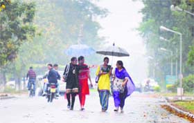 Weather shades: Girls use umbrellas to protect themselves from rain in Ludhiana on Monday