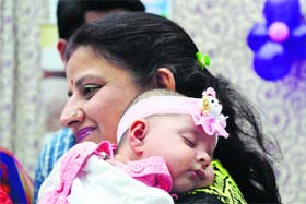 A child sleeps on her mother’s shoulder during a baby show organised by Whizkids e-Learning Play School at Lions Club, Udham Singh Nagar, Ludhiana