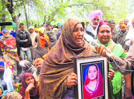 Swaranjeet Kaur displays a photograph of her deceased daughter during a dharna in Fazilka on Monday. 