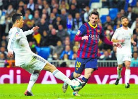 Real Madrid's Cristiano Ronaldo tries to tackle Barcelona's Lionel Messi during their Spanish league "Clasico" match at the Santiago Bernabeu stadium in Madrid on Sunday