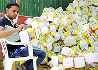 A BJP worker takes off Modis stickers from plastic bottles meant to seek donations, at Delhi party office in New Delhi on Tuesday