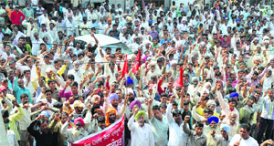 Brick-kiln workers shout slogans outside the Labour Commissioners office in Ludhiana on Tuesday. 