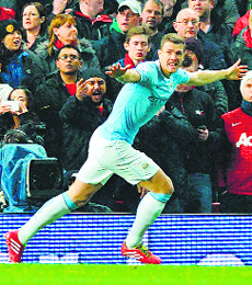 Manchester Citys Edin Dzeko celebrates after scoring the opening goal during their match against Manchester United in Manchester on Tuesday night.