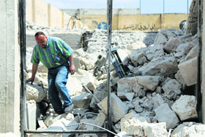 A man walks on debris of collapsed buildings at a site hit by what activists said were barrel bombs dropped by forces loyal to Syria's President Bashar al-Assad in Karam homad district in Aleppo on Wednesday. Reuters