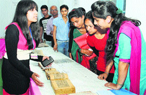 Students click photographs of manuscripts displayed during an exhibition by the National Mission for Manuscripts at DAV College, Jalandhar, on Thursday.