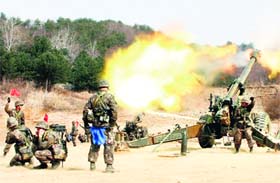 South Korean army personnel fire 155 mm howitzers in a live fire drill during the annual exercise in Inje, near the border with North Korea, on Thursday