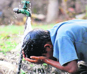 A boy pours water on his head to cool himself in Dehradun on Friday. The temperature has witnessed a sharp rise in the city.