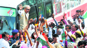 Chief Minister Bhupinder Singh Hooda waves to the crowd during his roadshow at Machroli village in Panipat district on Friday