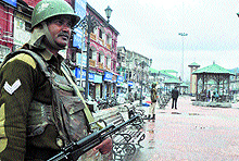 A security personnel stands guard in the Lal Chowk area in Srinagar on Friday