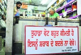 A banner dissuading people not to sell votes for liquor displayed at a liquor vend in Ludhiana.