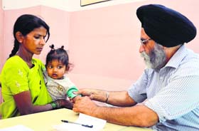 A doctor examines a child during a medical check-up camp at SNS Pahwa Hospital in Ludhiana on Sunday. As many as 801 patients were examined. Tests, including haemoglobin, blood sugar, urine and ECG, were done free of cost.