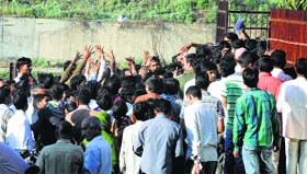 People try to catch reservation forms being thrown by an employee at the Dhandari railway station in Ludhiana on Sunday.