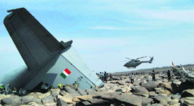 A helicopter flies near the debris of the recently crashed C-130J Hercules aircraft of the IAF in Madhya Pradesh.
