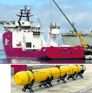 Australian defense ship Ocean Shield lies docked at naval base HMAS Stirling as a Phoenix underwater mapping robot (left) is being fitted to her, in Perth on Sunday. The robot will help her in the search for missing Malaysia Airlines Flight MH370