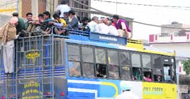 Flouting norms, passengers travel atop a private bus in Amritsar.