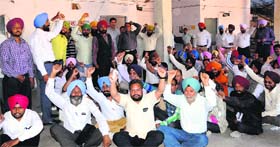 State government employees hold a protest outside the treasury office in Amritsar on Monday.