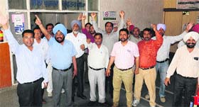 Members of teachers union protest outside the district treasury office demanding the release of their salaries in Bathinda on Monday.