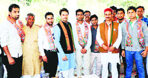 BJP Hamirpur segment candidate Anurag Thakur and state party president Satpal Singh Satti with youth newly inducted into the BJP at Malahat village in Una on Monday. 