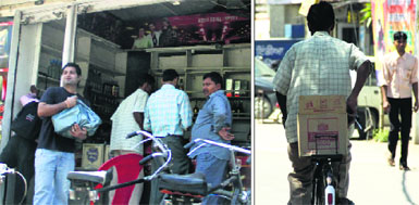 Booze lovers throng a liquor shop; and (right) a man carries a box of liquor after city liquor vends announced a huge discount in Jalandhar on Monday.