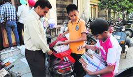 A parent helps his children bind the newly bought books in Bathinda on Tuesday.