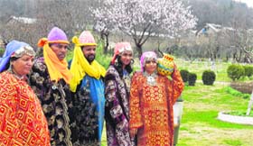 Tourists pose for a photograph at Badamwari garden blooming with almond trees in downtown Srinagar.