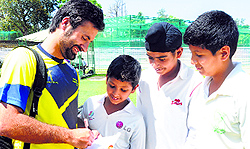 Parvez Rasool signing autographs for young cricketers at the Sector 16 cricket stadium in Chandigarh on Tuesday