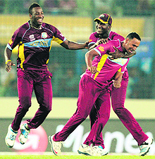 Darren Sammy (C) congratulates Samuel Badree (R) after the dismissal of Umar Akmal in a crunch match at the Sher-e-Bangla National Cricket Stadium in Dhaka