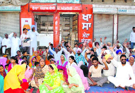 Residents of Paras Ram Nagar stage a dharna demanding the shifting of a liquor shop in Bathinda on Wednesday.