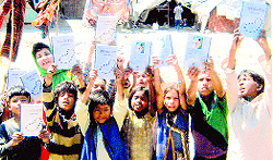 Slum children release a book related to Gurbani in Ludhiana on Wednesday