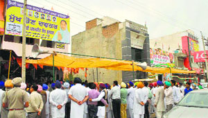 Congress and Akali supporters gather in front of their respective offices, which are located in adjoining buildings, in Faridkot on Wednesday. 
