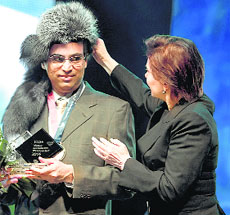 Viswanathan Anand gets a traditional Russian cap from an official in Khanty-Mansiysk, Russia, during the closing ceremony of the Candidates tournament on Tuesday night. 