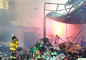 A Thai fireman stands inside a scrap metal warehouse after a massive World War II bomb that workers tried to cut open exploded in Bangkok on Wednesday