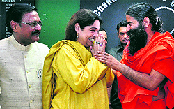 BJP candidate Kirron Kher greets yoga guru Baba Ramdev at a press conference in Chandigarh on Thursday. Also seen in the picture is former MP Satya Pal Jain