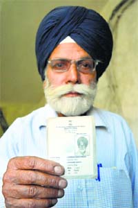 Gurbax Singh Middha shows his voter ID card.