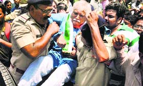 Policemen detain Congress candidate Madhusudan Mistry in Vadodara on Thursday.