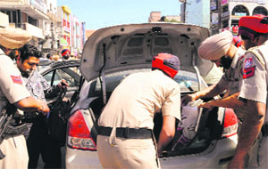 Cops check a vehicle ahead of the Lok Sabha elections in Amritsar on Friday.