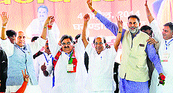 BJP Chief (extreme left) Rajnath Singh waves to the crowd at an election rally in support of party candidate Ashwini Chopra at Gharaunda grain market in Karnal on Friday